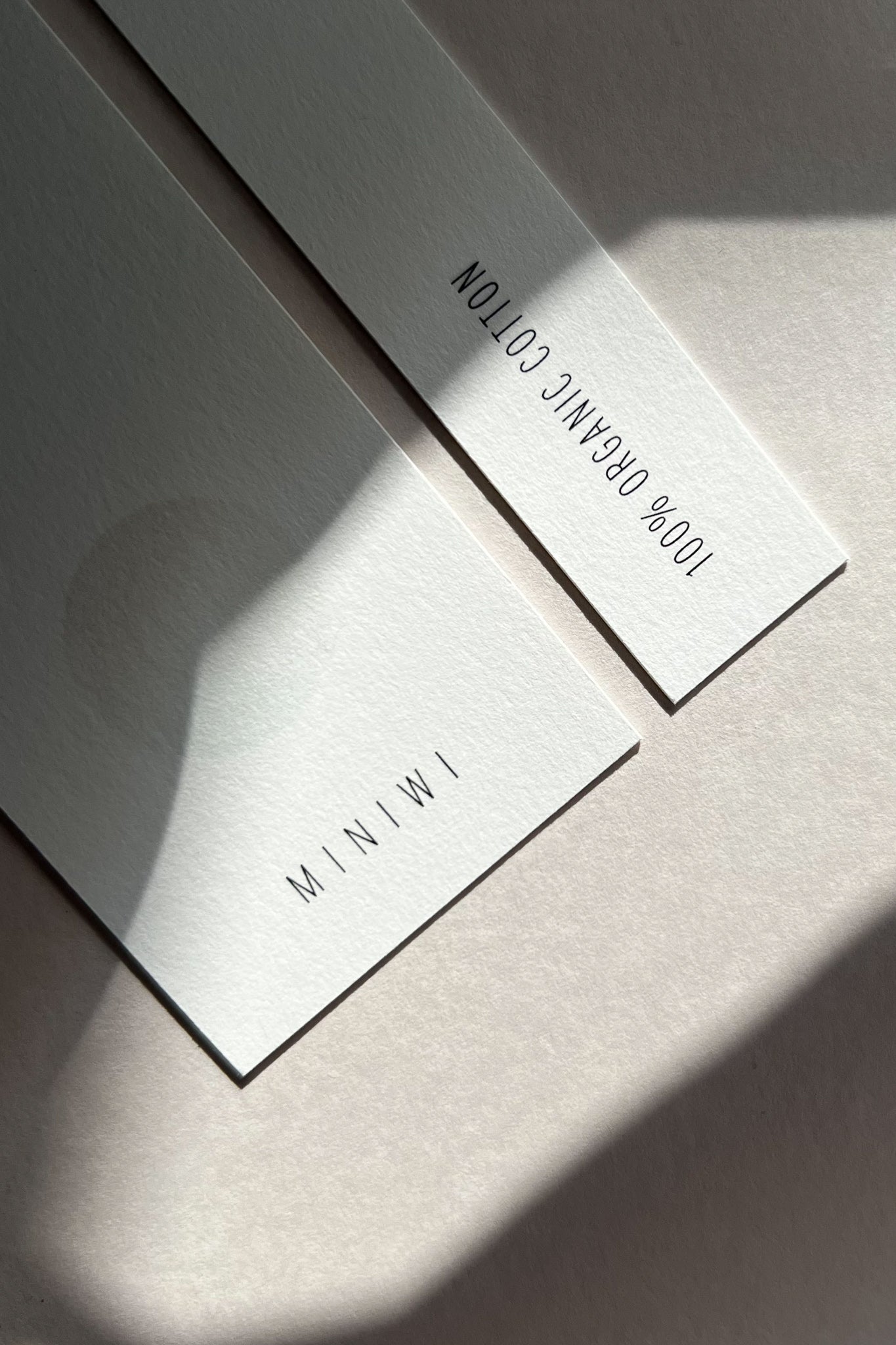 Two minimalistic tags. Miniwi and 100% organic cotton text